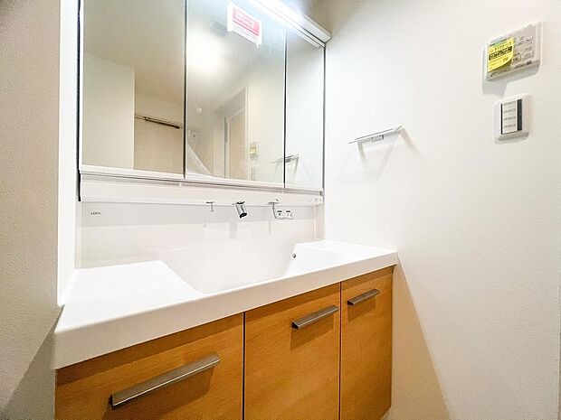 シャワー機能付きの洗面台にはワイドな三面鏡、使いやすい横長ボウル、スマートに収まる収納と充実しています。あわただしい朝の洗面タイムに心強い設備です。