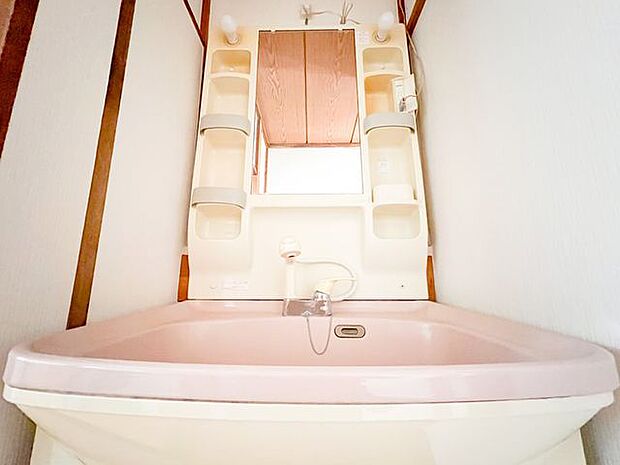 かわいいピンク色の洗面台がございます。収納もありますので使い勝手がよさそうです。