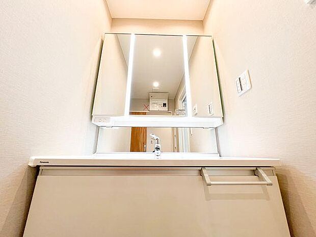 使いやすい三面鏡の中やベースキャビネットには収納スペースもたっぷり。手入れしやすいシャワー機能付洗面化粧台