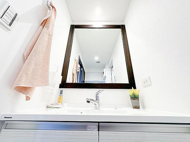 質感豊かな素材と使い勝手が魅力の洗面台、快適な脱衣エリアとなります。一枚鏡が清潔感を与えてくれます。