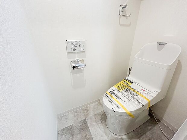 ウォッシュレット付きのトイレ。白を基調にした落ち着いた空間になってます。