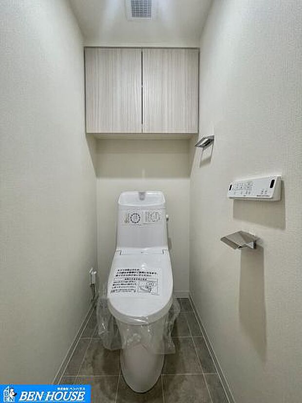 ・新規交換済のシャワー洗浄機能付のトイレ・清潔感が印象的な空間です・リモコンは壁掛けタイプでお手入れもしやすい設備です・吊戸棚も設置されトイレットペーパーやお掃除道具もしまえますね