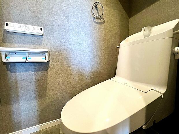 アクセントクロスが採用された、お洒落なトイレです。毎日快適に使える温水洗浄便座付き。