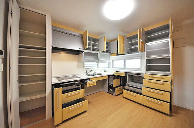 数え切れないほどの収納スペースが魅力のキッチン。さらに横には背の高い棚付きの物入もあります。