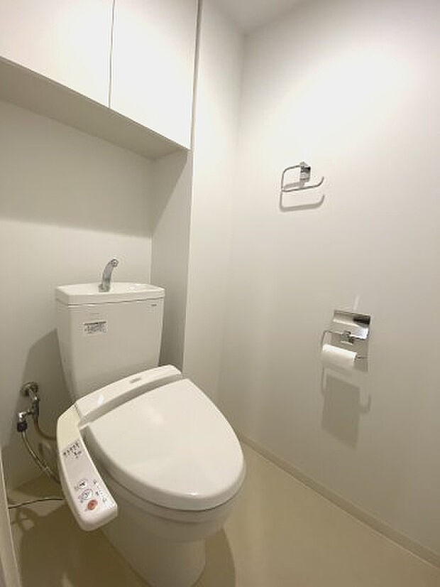 洗浄機能付温水便座トイレ。上部に棚があるので、トイレ用品が収納できます。