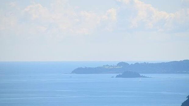 ズーム写真：奥に伊東沖の手石島、その先に川奈ホテルのゴルフコースが見えます。