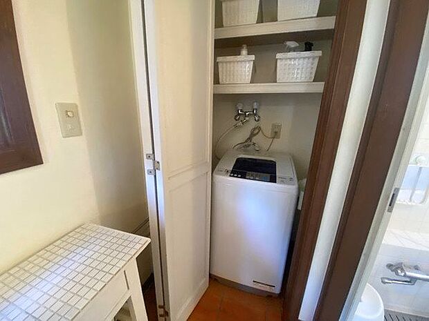 【洗面室】収納内に洗濯機置場が設えております。