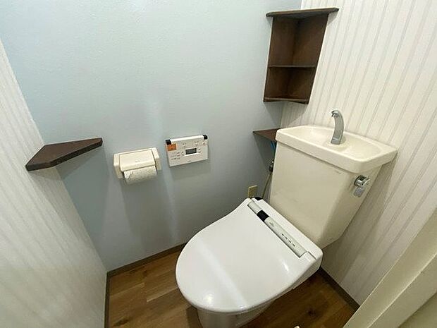 トイレ空間。広く見えるアクセントクロスがリゾート感を演出。
