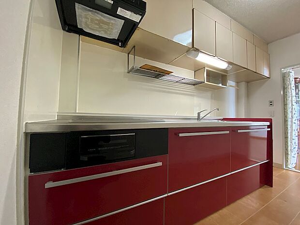 キッチン：赤が特徴のシステムキッチンになります。収納も多く使い勝手が良さそうです。