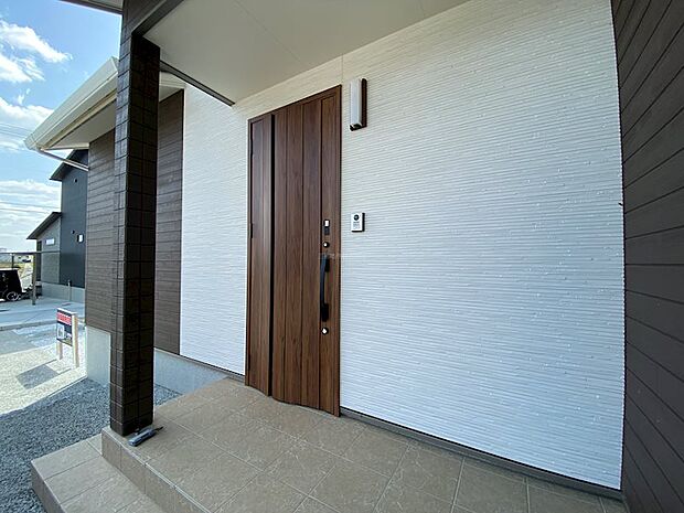 デザイン性のある木目の玄関ドア。ダブルロックに加えて便利なリモコンキーつき