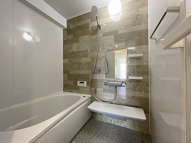 浴室：ブラウンのアクセントパネルで落ち着いた空間に。浴槽も広くゆったりくつろげて疲れもすっきり。
