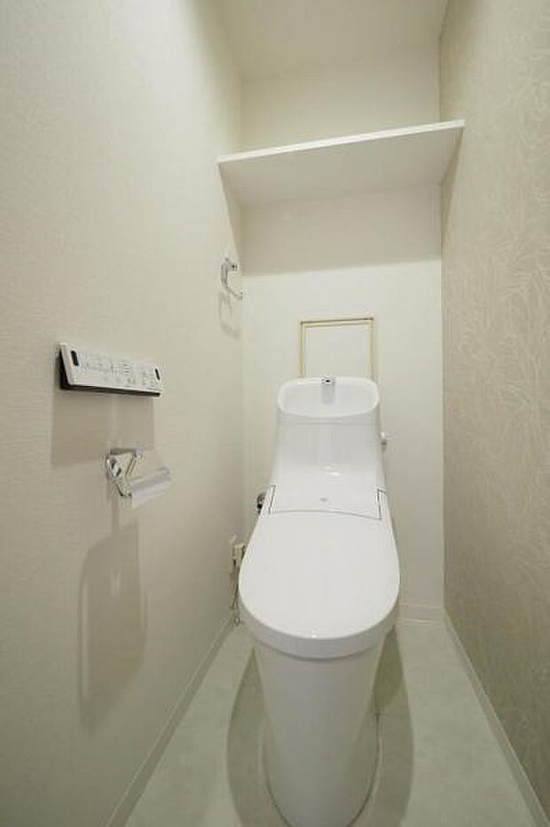 温水洗浄便座付トイレ。上部に棚が備わっているので、トイレットペーパーの予備も保管しやすいです。