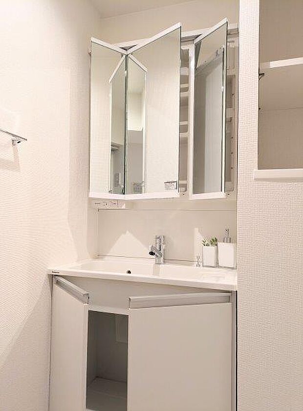 白を基調とした清潔感のあるパウダールームです。鏡裏には歯ブラシや化粧品も収納できます。 