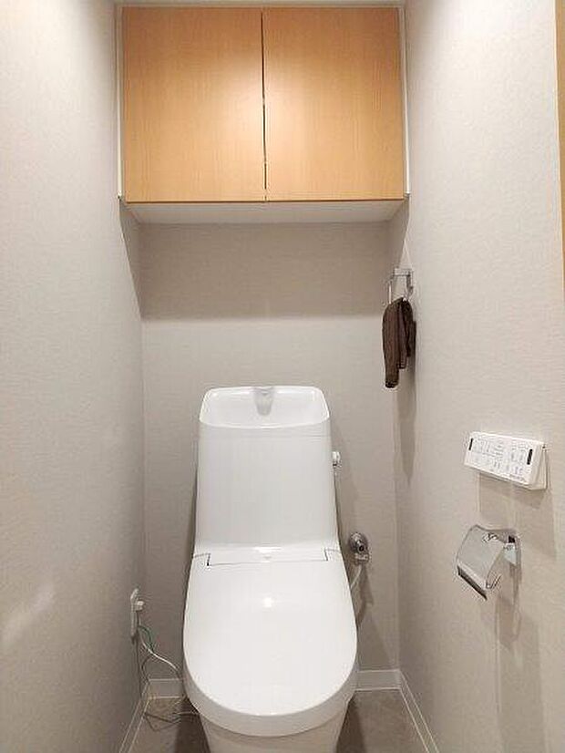 清潔で快適な温水洗浄機能付トイレです。上には吊り棚を設置しており、日用品を収納できます。 