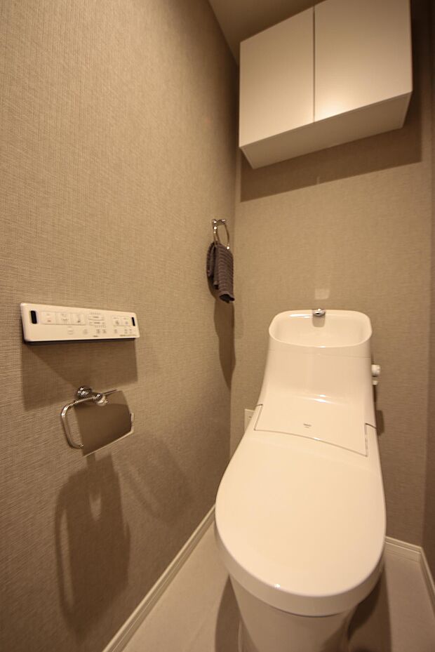 清潔で快適な温水洗浄機能付トイレです。上には吊り棚を設置しており、日用品を収納できます。 