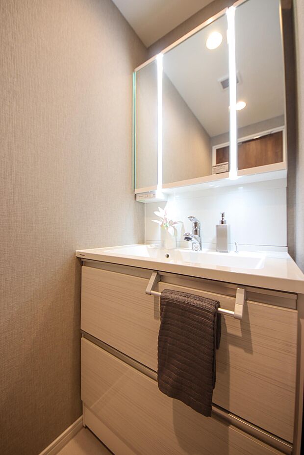 仮置きスペースが広く、朝の身支度もしやすい独立洗面台です。三面鏡裏には歯ブラシや化粧品も収納できます！ 