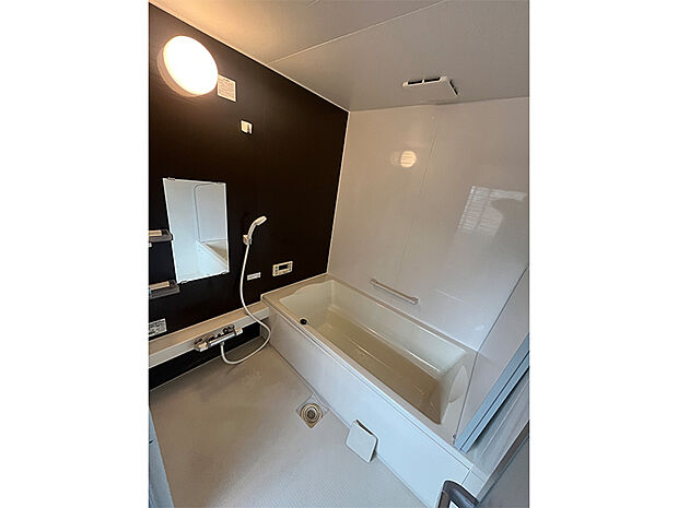 【浴室】明るく清潔感のある浴室です。立ち上がりをサポートする手摺り付きで、シニア世代にも使いやすい設計。洗顔に便利な鏡も設置されています。