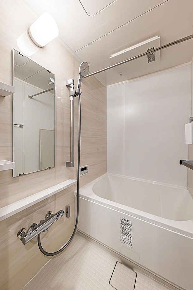 バスルーム｜木目調をデザインした、心落ち着く浴室です。縦に長い鏡は、身長を問わずお使いいただけて便利です。浴室乾燥機付きで、雨の日も生乾きの匂いに悩まされません。