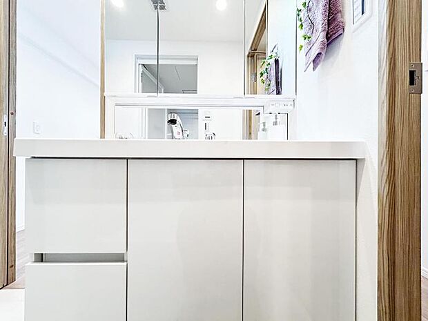 白の清潔感あふれる洗面化粧台には、収納スペースが備わり朝の忙しい時間もスムーズに身支度ができます