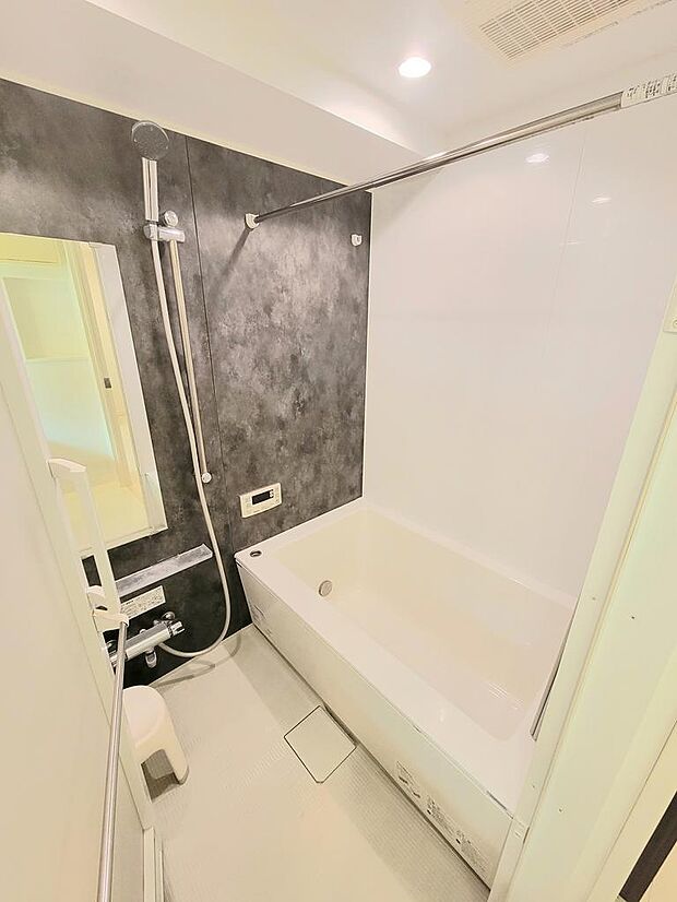 清潔感のあるシンプルなデザインの浴槽。浴室の壁はデザインパネルで高級感と落ち着いた雰囲気を演出しています。24時間換気、浴室乾燥機等、充実の機能が付いています