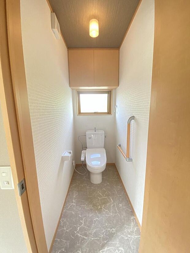 【リフォーム済】トイレは新品に交換し、クロスの貼替を行いました。手すり付き。上部には収納スペースも付いております。