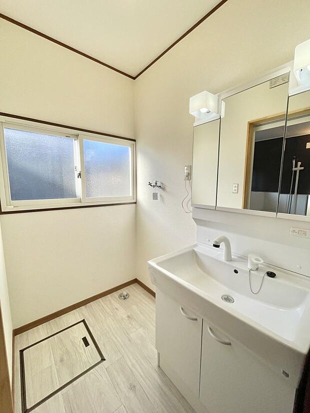 【リフォーム済】洗面所を撮影しました。天井・壁はクロス張替、床はクッションフロア張替を行いました。洗濯用水栓は新品交換を行いました。