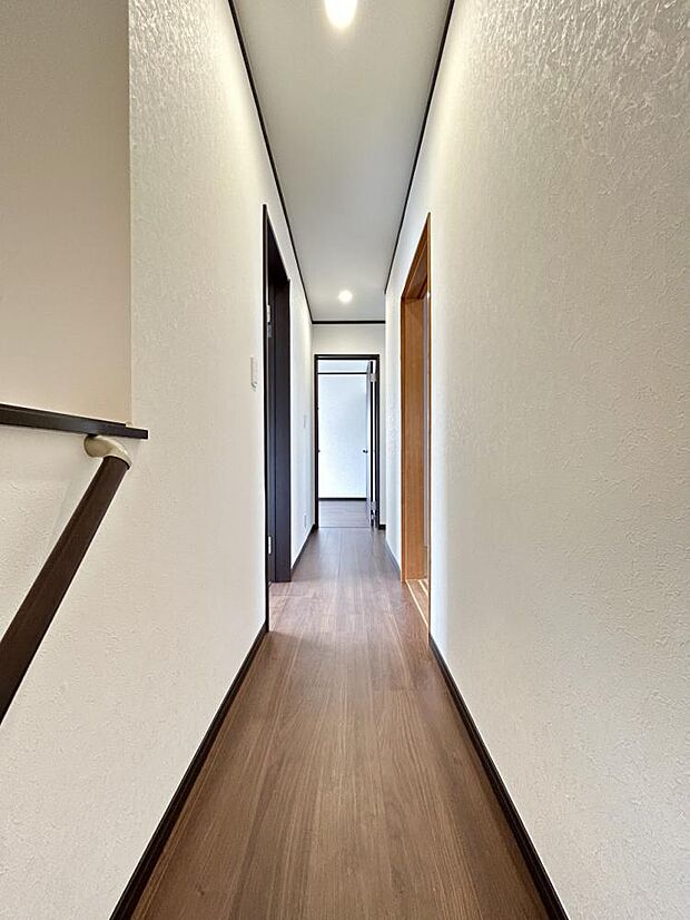 【リフォーム後写真】2階の廊下です。フローリング重ね張り、クロス張替、建具・照明交換を行いました。