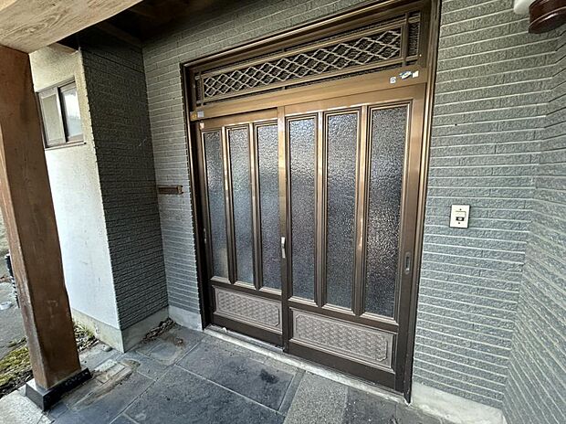 【リフォーム中・玄関】住宅の顔と呼ばれる玄関の引き戸は新品のものに交換致します。また玄関灯も交換するほか、タイルも綺麗にクリーニングすることで引き締まった印象に生まれ変わります。