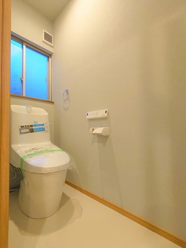 【リフォーム後】トイレの写真です。リクシル製の新品のトイレを設置してクロスの張替、床材の張替を行いました。