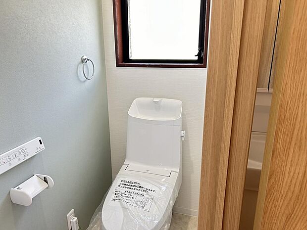 【リフォーム済】2階トイレの写真です。トイレはリクシル製の温水洗浄機能付きに新品交換しました。表面は凹凸がないため汚れが付きにくく、継ぎ目のない形状でお手入れが簡単です。節水機能付きなのでお財布にも優