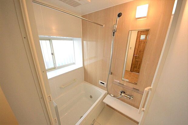 白基調と木目調で暖かな色合いの浴室、お手入れしやすい仕様です