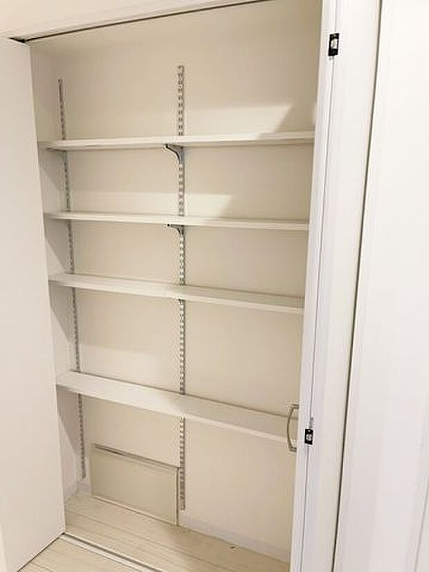 廊下に設置のシステム収納。お掃除用具や、リビングに置ききれない本などの置き場として活用できます。