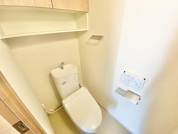 ≪トイレ≫ 温水洗浄機能付き便座と上部収納棚付きのトイレになります。