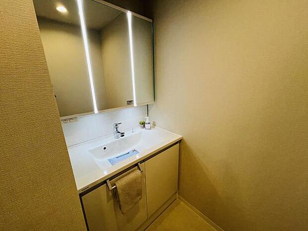 三面鏡の洗面化粧台は縦に配置したLED照明により、左右からの光で顔に影を作りません