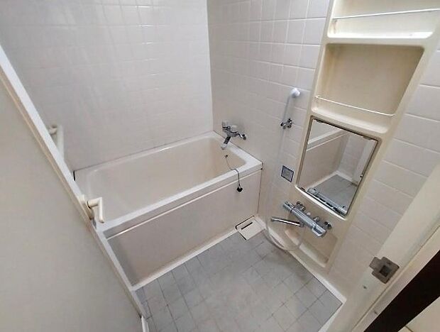 お掃除がしやすい白いタイルづかいの浴室。追い焚き機能、浴室換気乾燥機搭載のユニットバス。