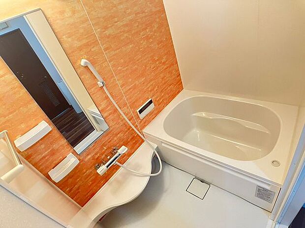 オレンジのパネルでおしゃれにコーディネートしたバスルーム♪鏡やカウンターを設け、使い勝手が良いお風呂です！
