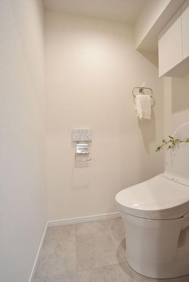 吊戸棚を設置した白基調の清潔感あるトイレ