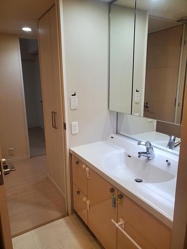 家事動線の良い2wayの洗面脱衣所でキッチンや廊下側の出入りが可能。三面鏡タイプの洗面化粧台は、鏡の裏が収納になっており、ボウル回りをスッキリお使いなれます