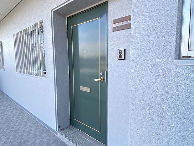 ご家族、お客さまを迎え入れるグリーンの落ち着いた色合いの玄関扉。セキュリティー対策として使えるモニタ付きインターホンが付いています。