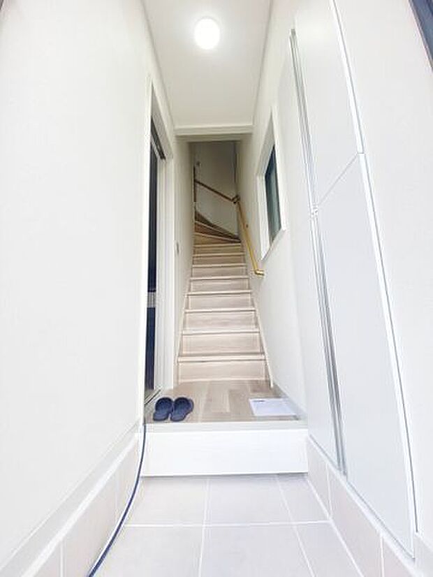 白を基調とした清潔感のある玄関玄関タイル・フローリング新規張替