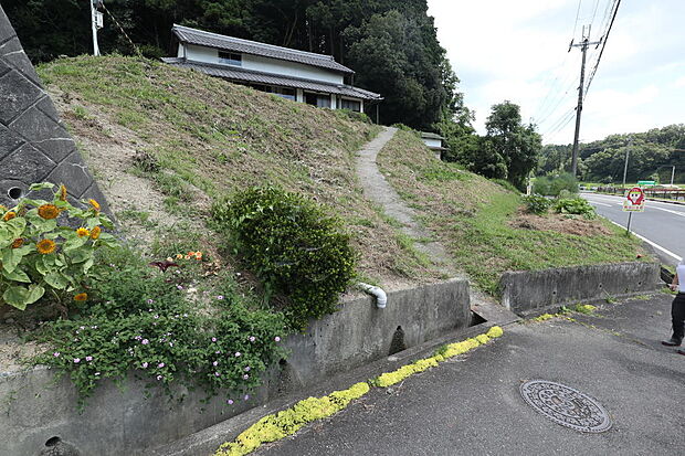 前面道路から敷地は小高い斜面を登ります。