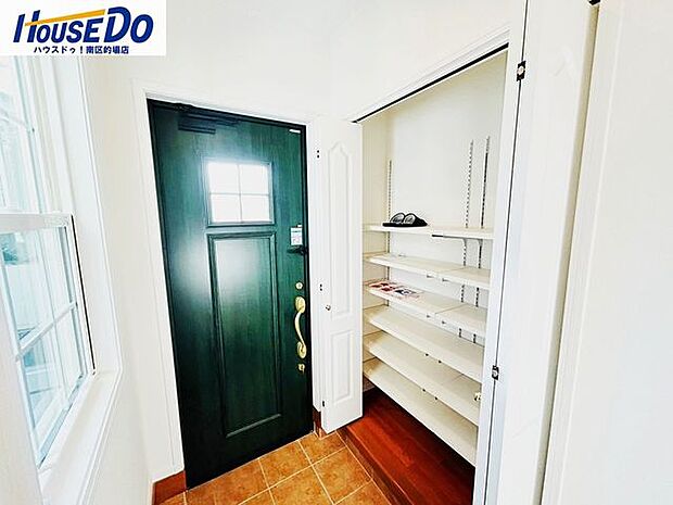 グリーンの玄関ドアが印象的で壁面収納です。靴はもちろん、折畳傘なども収納できるので玄関をすっきりと見せられます。