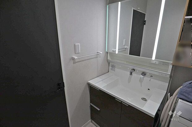 洗面室。鏡後ろの収納が豊富です。コンセントがあり、身支度に便利です。