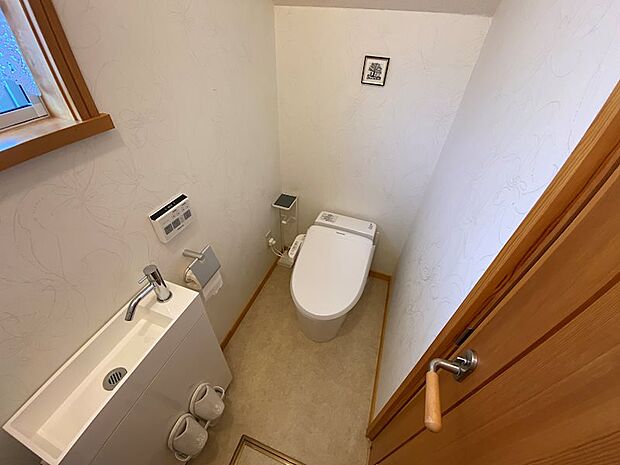 【1階トイレ】洗面台とウォシュレット機能付きトイレです。
