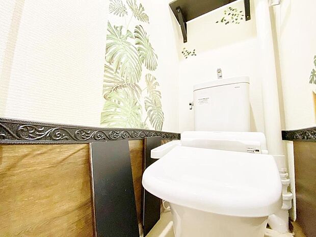 清潔感あるホワイト調のクロスと温もり溢れるモダンカラーの床材が見事に調和したトイレ。