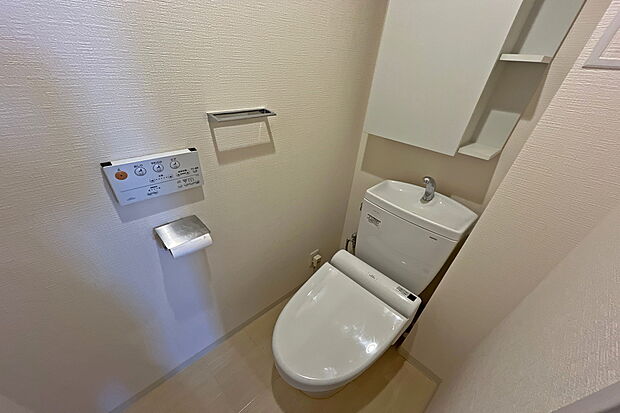 トイレ一面ホワイトの清潔感溢れる個室空間です。上部に収納があり生活感を隠すことができます。