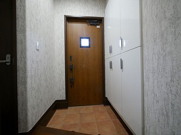 温かみのある木製の玄関ドア。小窓からは光が注いでくるので明るい空間となっています。