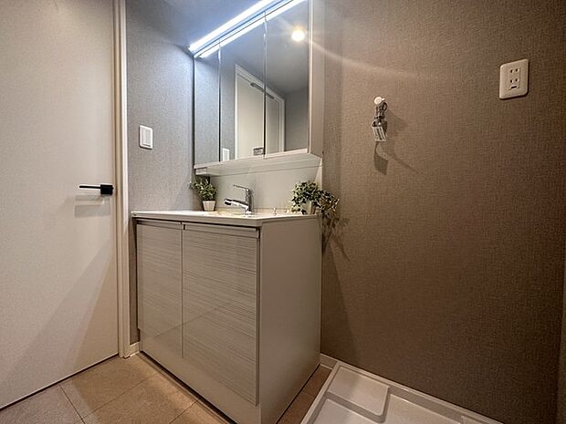 明るい面材を使用した洗面室。白い室内ドアが清潔感を演出し、心地よい明るさが広がります。快適な空間で、朝の身支度や夜のリラックスタイムをお楽しみください。    