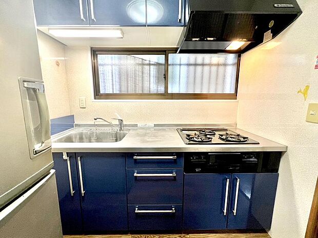 青のパネルが印象的なキッチンは窓もついているので採光もあり明るい印象です。