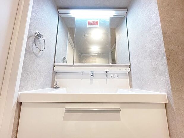 三面鏡の付いた洗面化粧台は、鏡面裏側にも機能的な収納を配置。スキケア用品などが衛生的に保管できます。